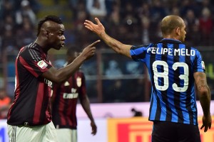 AC Milan's Italian forward Mario Balotelli (L) and Inter Milan's Brazilian midfielder Felipe Melo gesture during the Serie A football match between Inter Milan and AC Milan at San Siro Stadium in Milan on September 13, 2015 . AFP PHOTO / GIUSEPPE CACACE