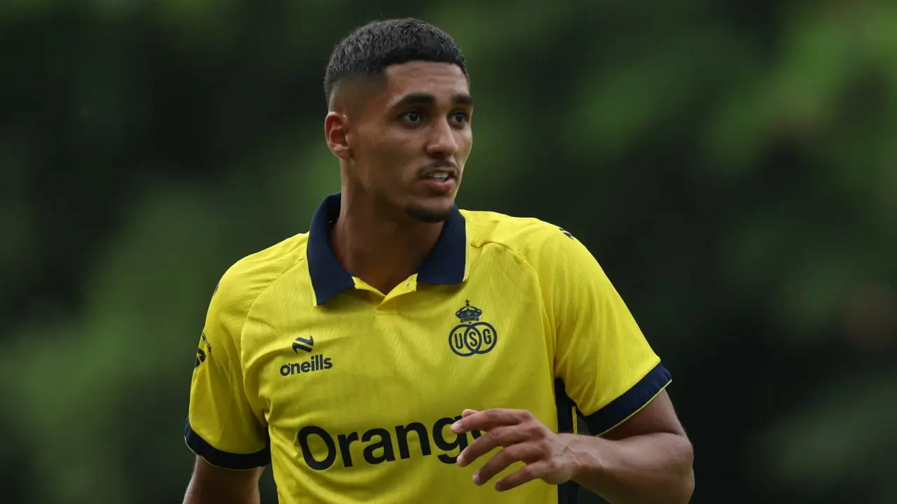 Football player wearing a yellow team jersey during a match.
