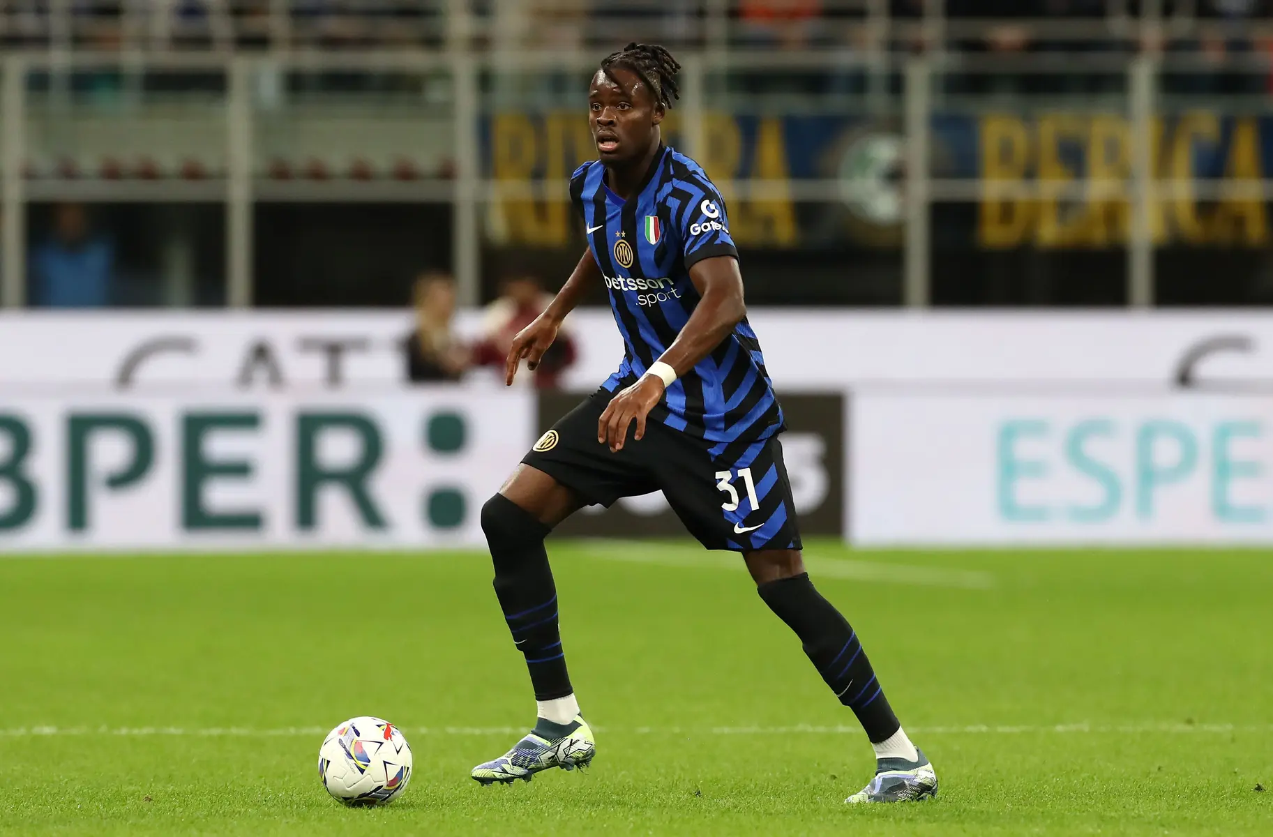 Yann Bisseck in Inter Milan blue and black striped kit with number 31 on his shorts controlling a soccer ball