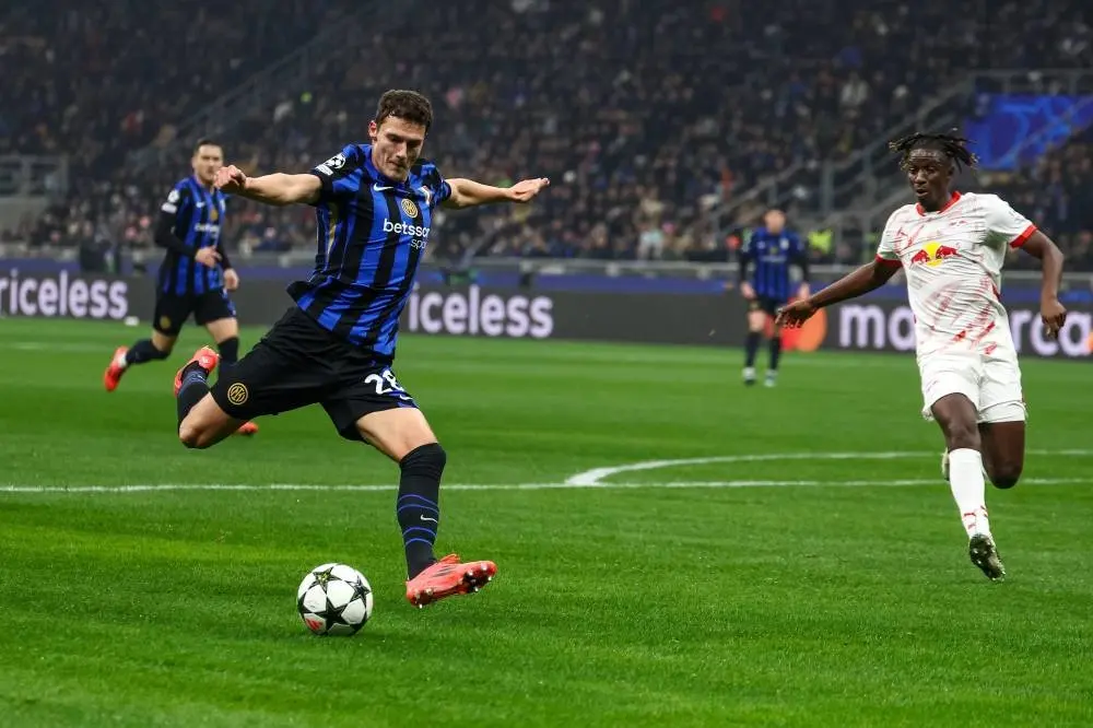 Benjamin Pavard in an Inter Milan kit kicking a soccer ball during a match against RB Leipzig