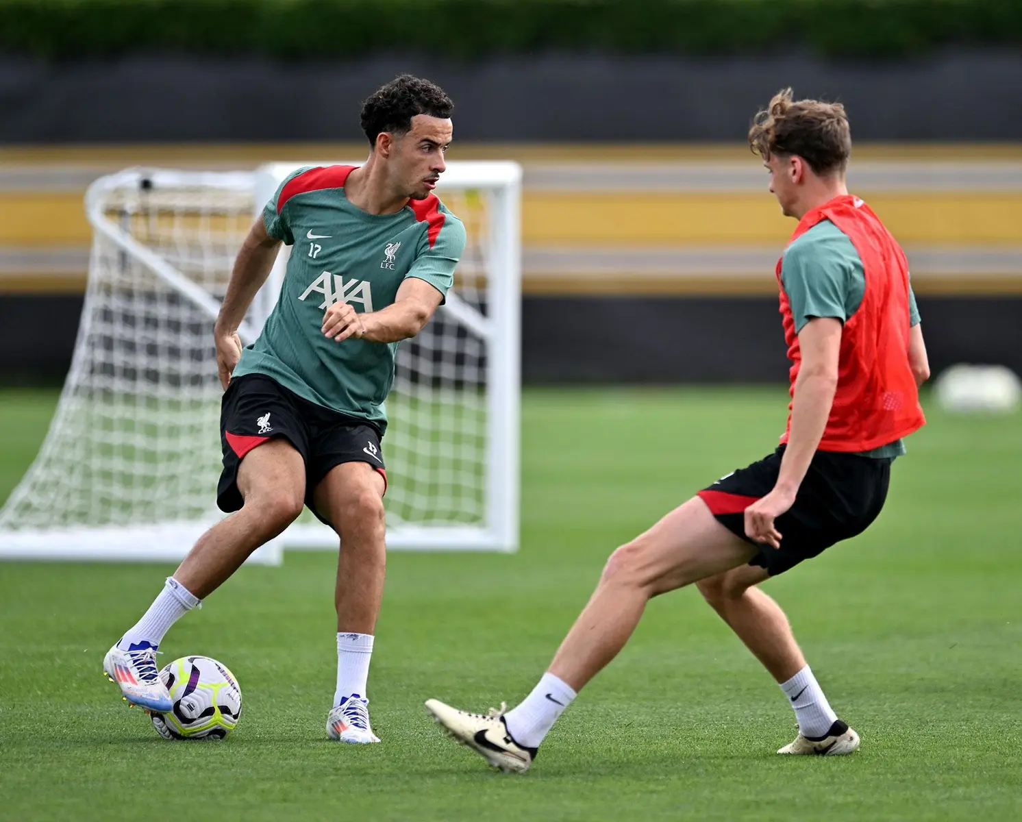 Curtis Jones in a green Liverpool FC training kit controlling a soccer ball on a practice pitch