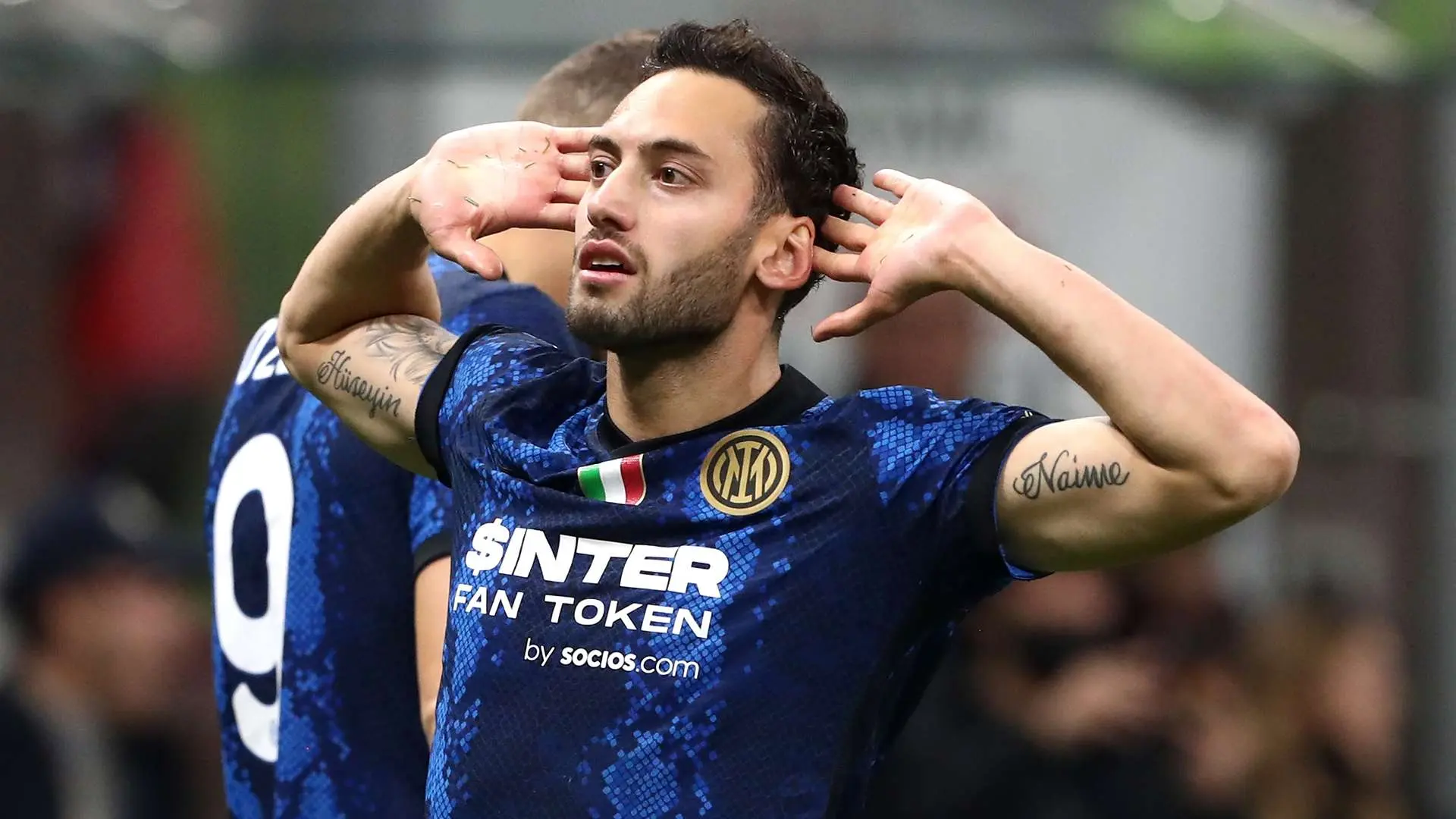Hakan Calhanoglu wearing an Inter Milan jersey with his hands to his ears
