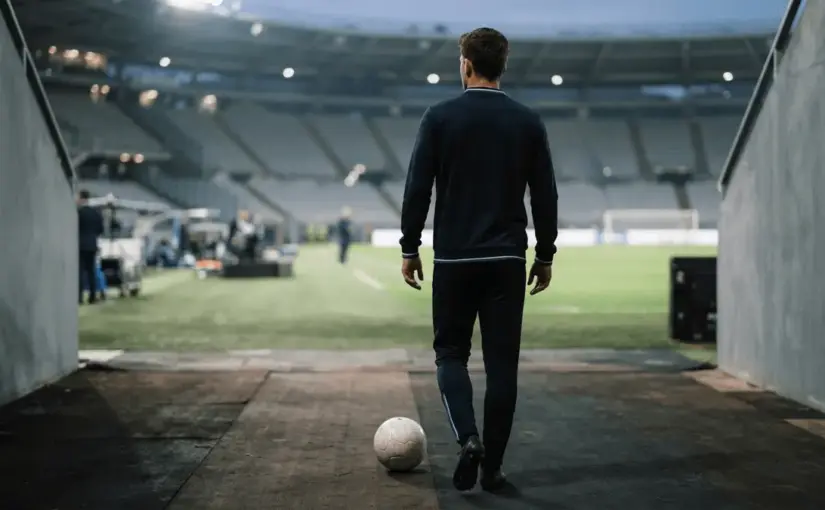 Football midfielder standing pitch-side in a floodlit stadium, representing a major Italian transfer