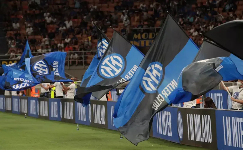 Inter Milan fans waving blue and black flags with the club logo in a stadium