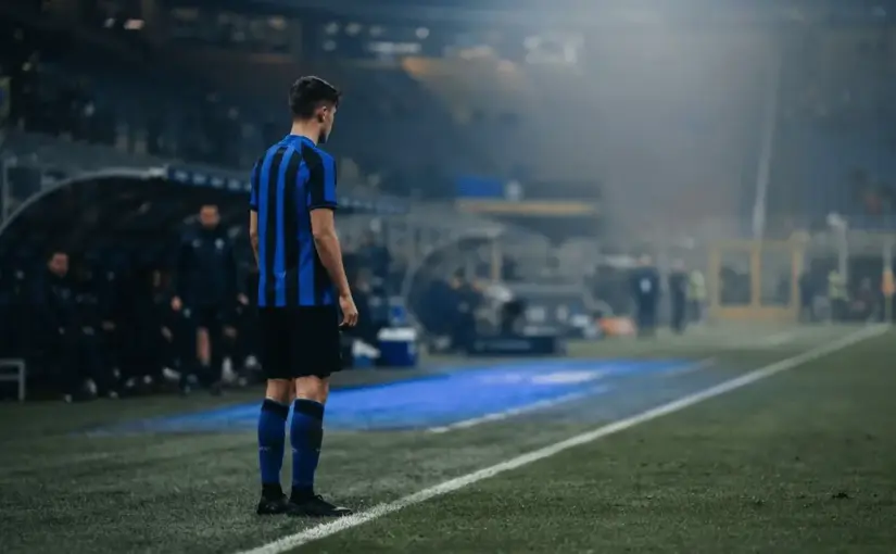 Young midfielder alone on a floodlit football pitch facing a crucial chance to earn more playing time