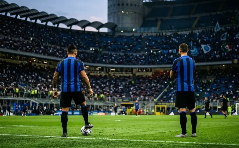 Two Inter-inspired forwards stand apart on a floodlit pitch before a Napoli match, representing an unresolved selection decision.