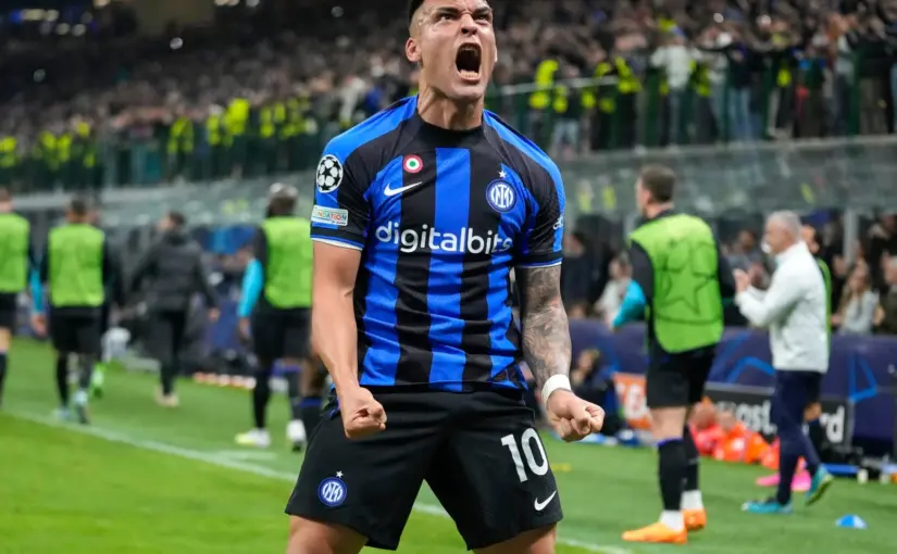 A football player in an Inter Milan blue and black striped kit celebrating on the pitch.