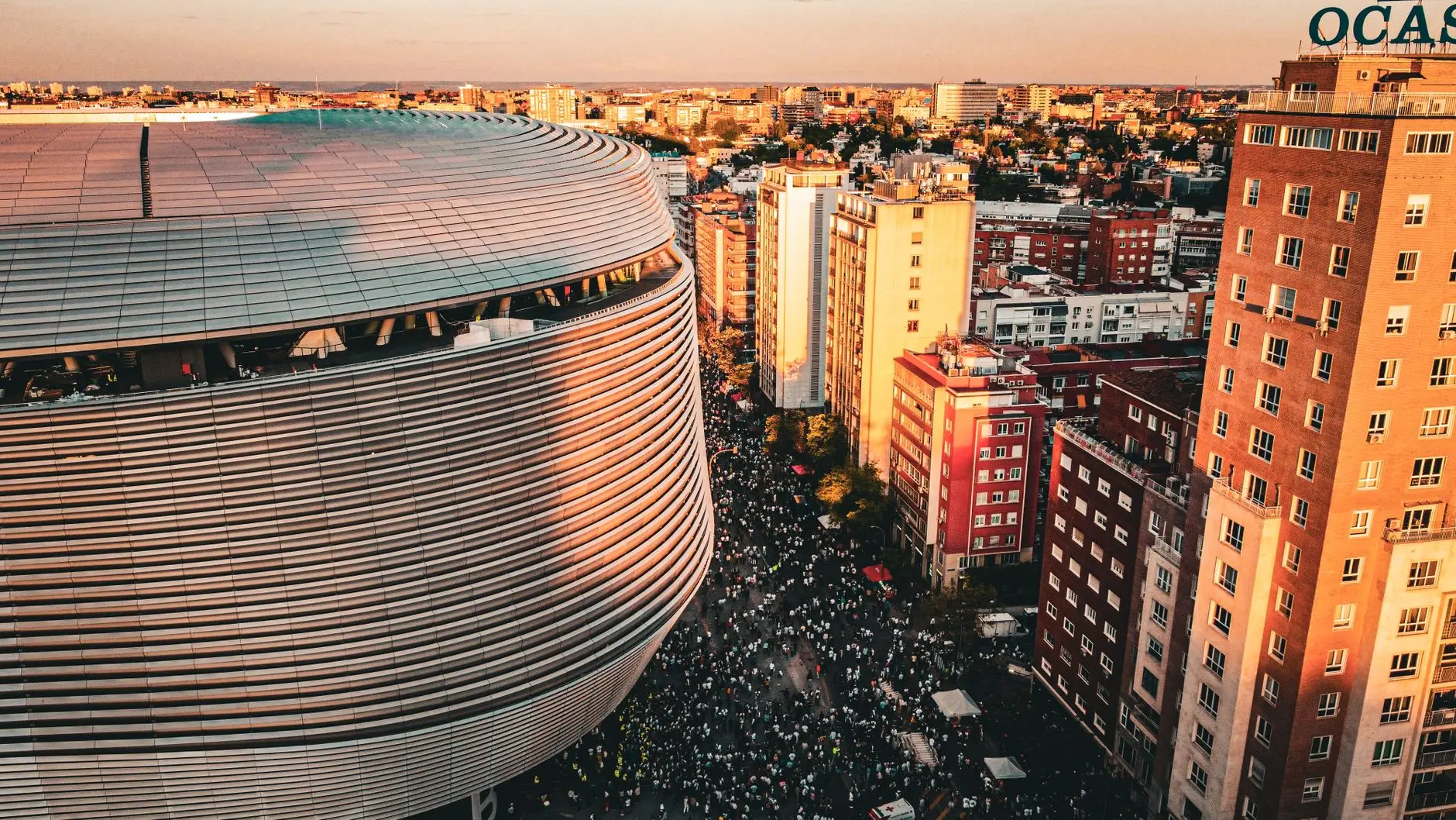 Aerial view of the modern Santiago Bernabéu Stadium in Madrid with crowds of people gathered outside